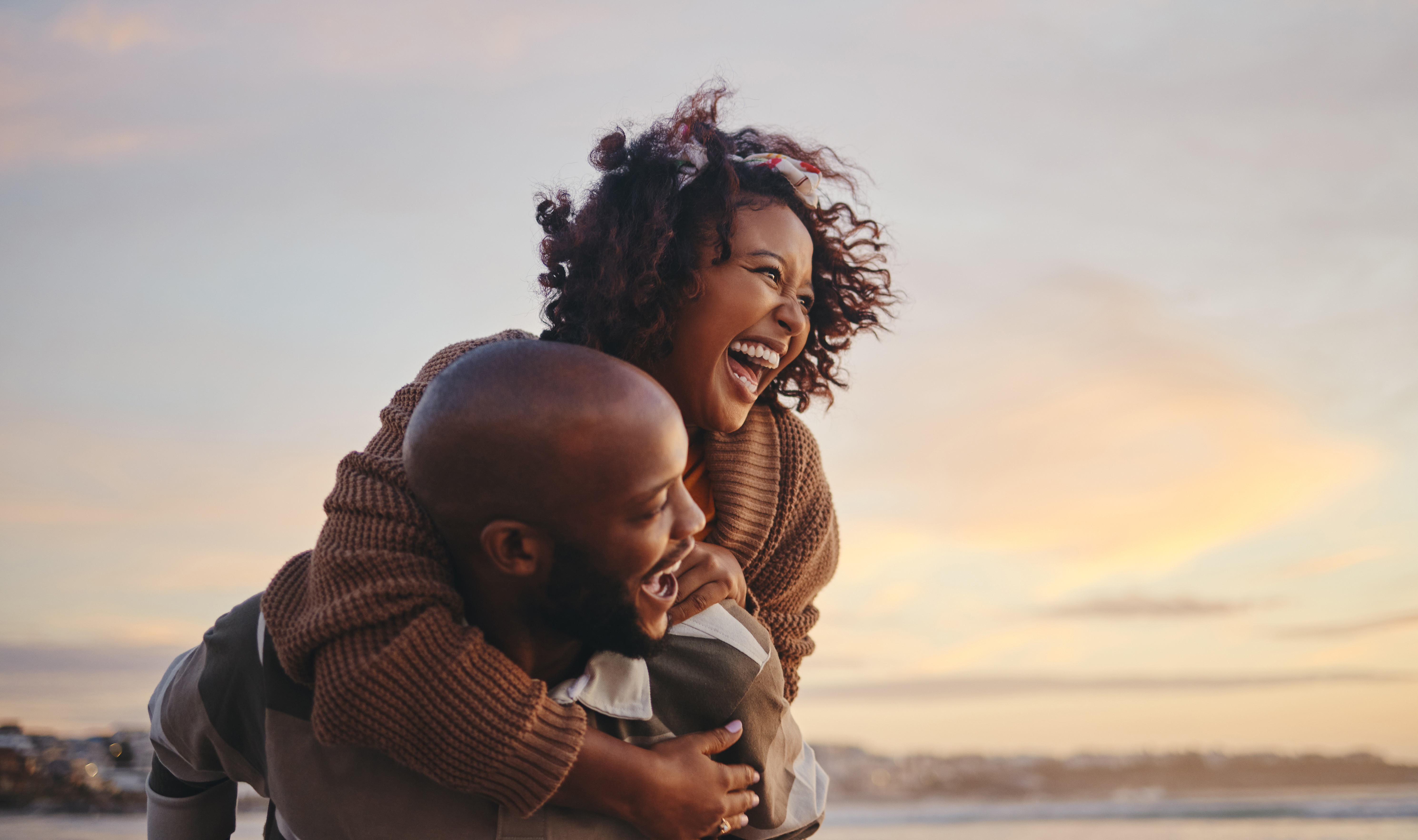 A happy couple embrace near the ocean