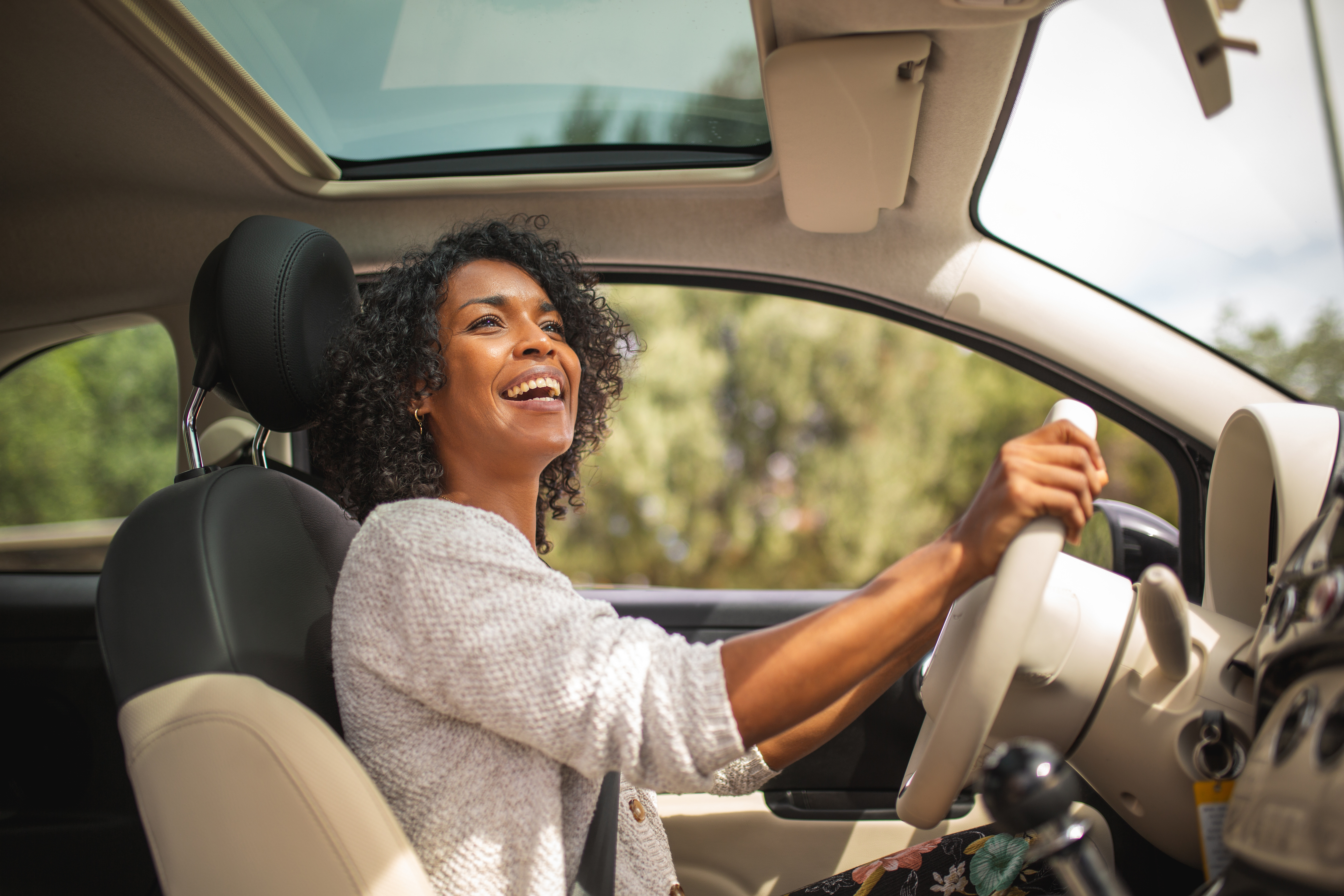 Woman smiling while driving her car